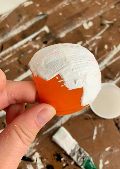 Paint pumpkin treat cups with white paint.