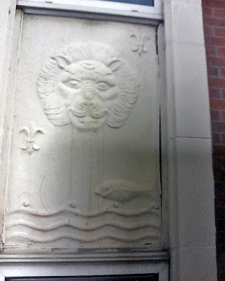 A lead panel of the same design as the plaque, with lion's head spouting water and fish swimming past