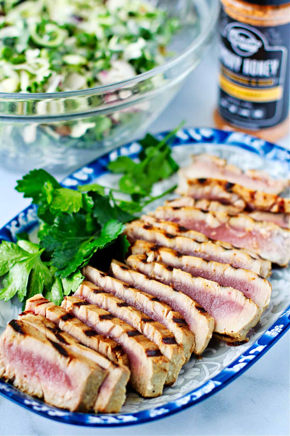 Grilled Tuna Steaks with Honey Vinaigrette on a serving plate with salad.