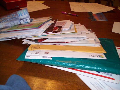 A large stack of mail laid out on a table