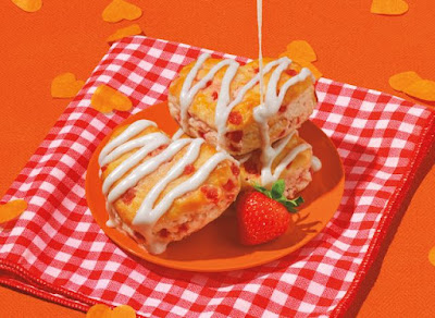 A plate of Popeyes Heart-Shaped Strawberry Biscuits on a checkered napkin.