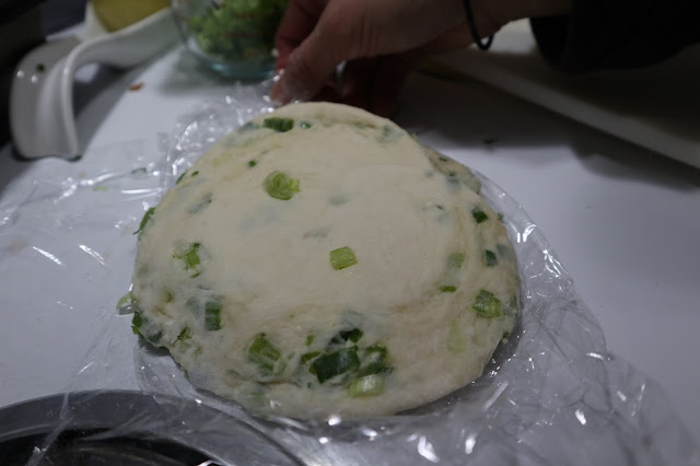 green onion cake with saran wrap on top