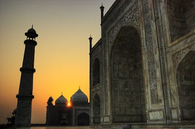 The Taj Mahal silhouetted against a vibrant sunset.