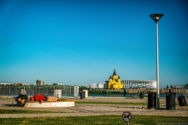 Два парня спят на лавочке на фоне Собора Александра Невского