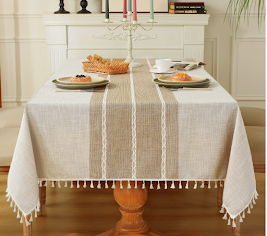 neutral tan table cloth with fringe on a wood table