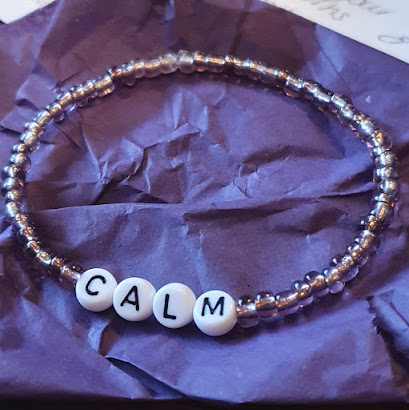 Bracelet made from small round purple beads, and large lettered beads spelling the word calm