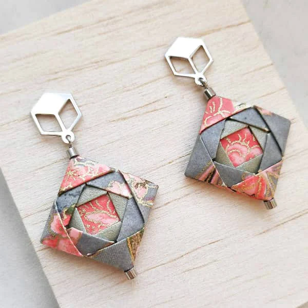 pair of peach and silver-grey folded floral patterned paper origami earrings displayed on backing card