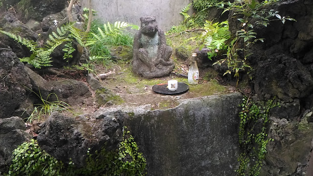 Un autel avec un dieu singe auquel on à offert un verre de saké