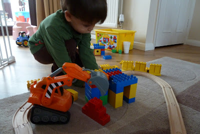 Child playing with Lego and digger