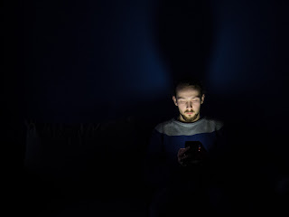 Hombre mirando su celular en la noche