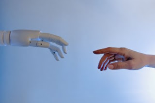 A close-up of a robot hand reaching for a human hand