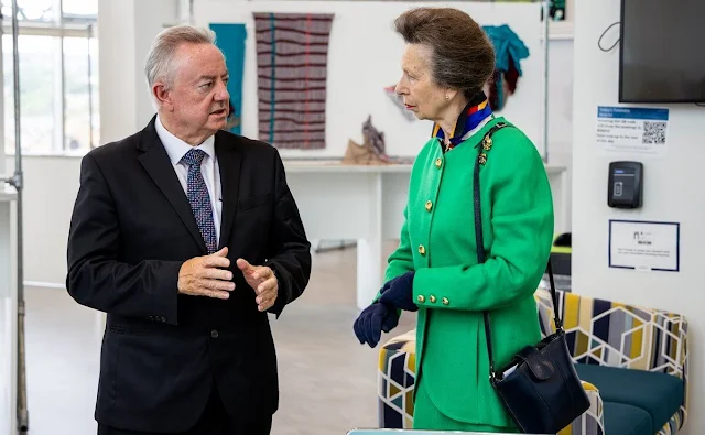 Princess Anne wore a green jacket and midi skirt, and silk shirt. Gold brooch. UK Fashion and Textile Association