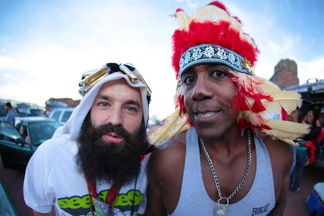 A guy wearing a Native American headdress and a guy wearing a Saudi headdress.