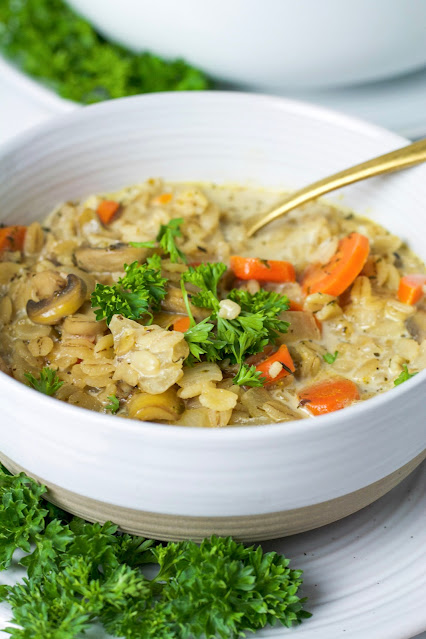 soup in a white bowl with parsley garnish on the side.