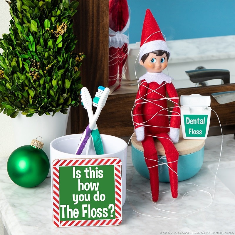 elf doing the floss with dental floss