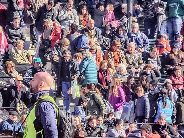 Gente en la tribuna con sol de frente