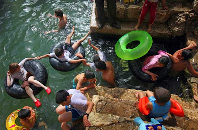 Israeli children enjoy the spring water of Nahal Prat, in the Judea Desert near the West Bank settlement of Alon, east of Jerusalem 