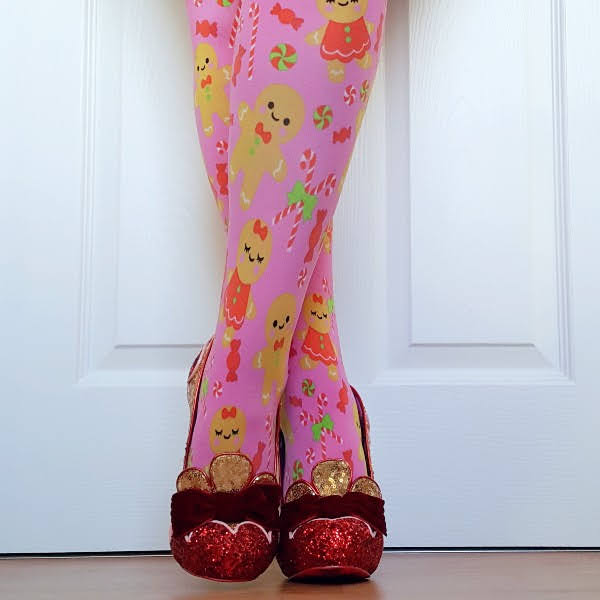 crossed legs in festive gingerbread print tights with gold and red glitter and sequins shoes