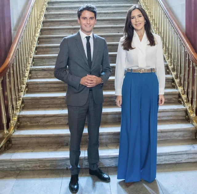 Crown Princess Mary wore a Bowery ivory stretch silk blouse by The Fold London. Princess Mary wore blue wide-leg pants