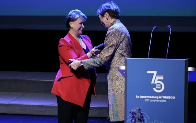 Duchess Maria Teresa wore a red asymmetric crepe blazer by Alexander McQueen. Artist Anne-Marie Herckes' Peace brooch