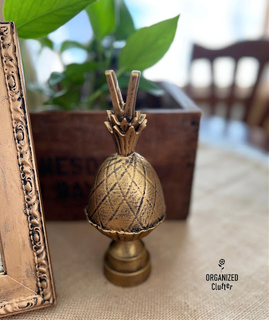 Photo of an antique brass faux finish on a metal pineapple finial.