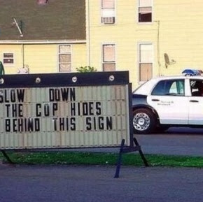 slow down the cop hides behind this sign