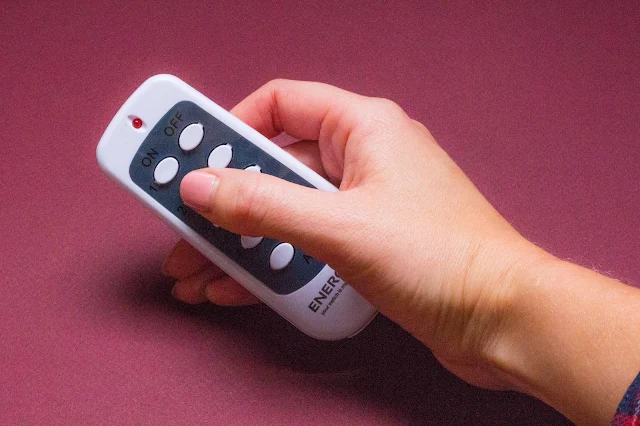 A small white and grey remote control with 10 buttons on to turn the adaptors on and off