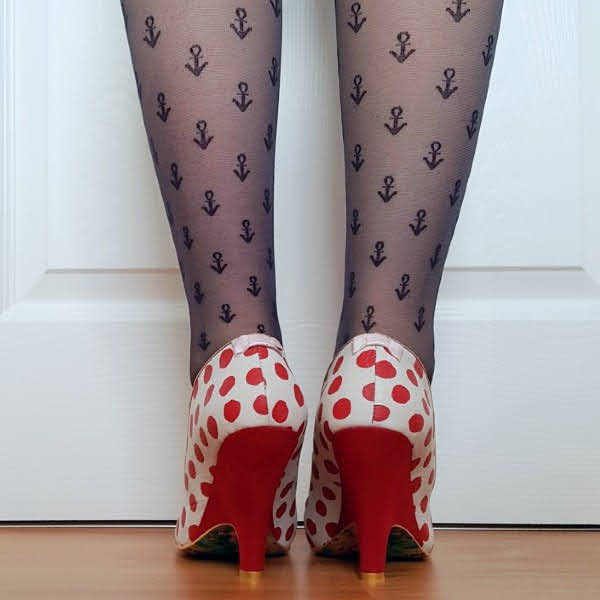 back of legs wearing red heels with small pink bows and polka dot uppers