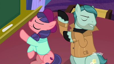 Raspberry Beret (left) and On Stage emote wildly with their forelegs. There is a blackboard to the left