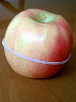 A rubber band is wrapped around a cut apple to keep the inside from being exposed and going brown.