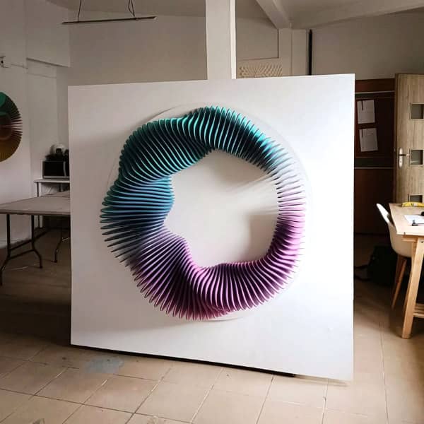 studio view of large-scale blue and purple painted plywood three dimensional wall relief