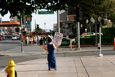 A spruiker holding up a 'Jesus Loves You' sign