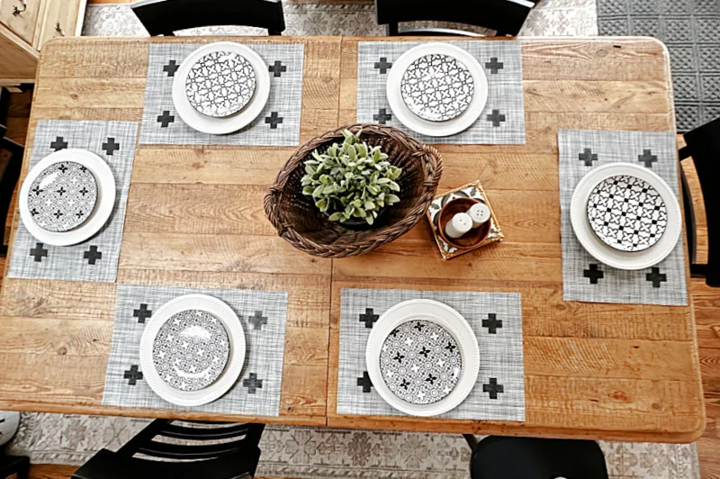 table with placemats and black and white dishes
