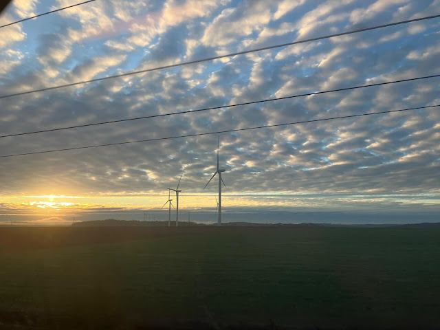 Wind turbines and electricity wires at sunset
