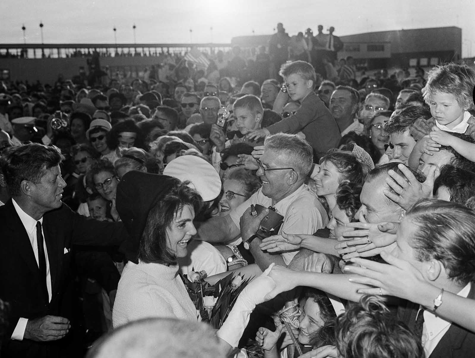 On November 21, 1963, President John F. Kennedy and first lady Jacqueline Kennedy shake hands with well-wishers who lined the ramp at Houston International Airport to welcome them to the Texas city.