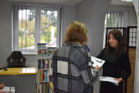 Pracownik Biblioteki Kamila Rudowska wręcza dyplom i nagrodę laureatowi konkursu.