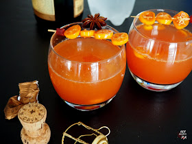 Cóctel rojo de cava para fiestas invernales, a base de sirope de granada, cítricos (kumquats y lima) y especias.