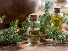 Bottles full of thyme oil with thyme leaves all around.