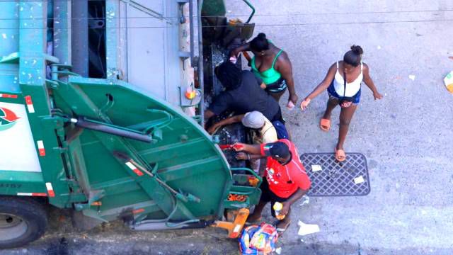 Pessoas procurando restos de alimentos em caminhão de lixo reflete o Brasil de Bolsonaro