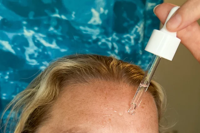 A close up of applying Depology serum to fine lines on my forehead