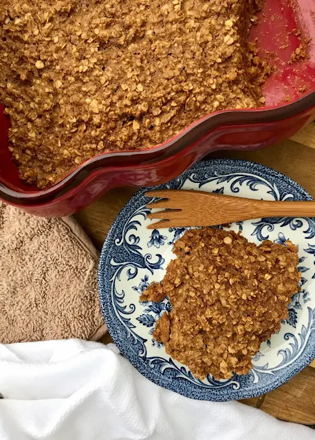 Baked gingerbread oatmeal in a baking pan and serving plate.