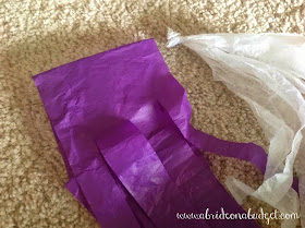 Make a tissue paper tassel garland in minutes without gluing with this tutorial from www.abrideonabudget.com.