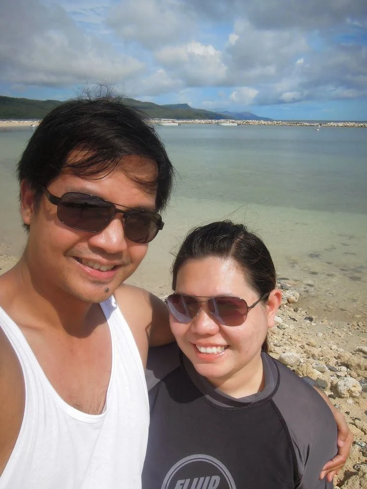 Couple travel bloggers in Misibis Bay's beach