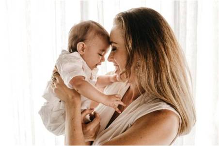 Mother with baby in her arms smiling