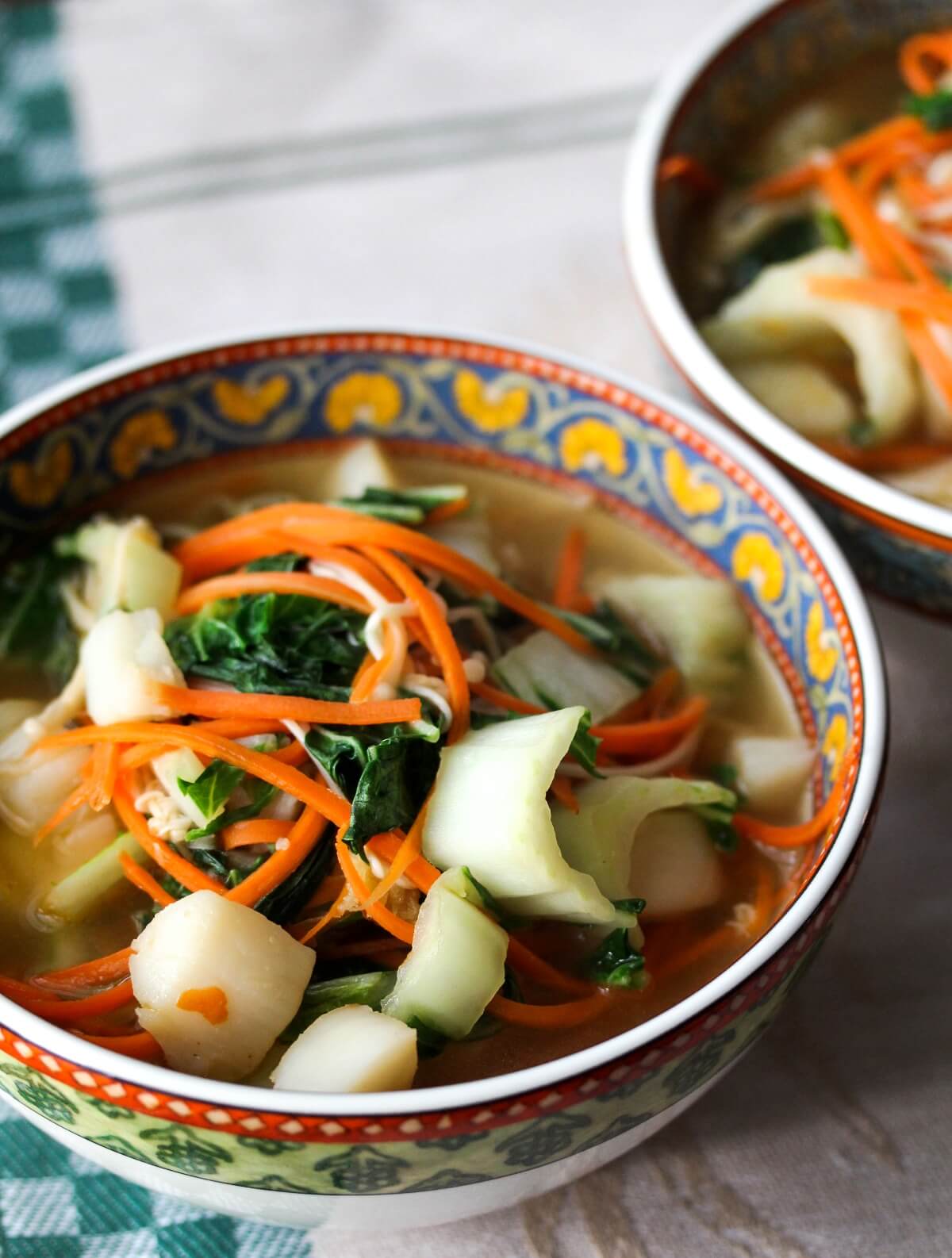 Bay scallop noodle soup with carrots in bowls.