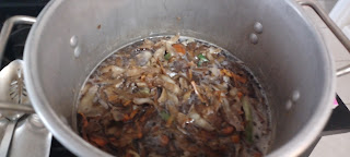 Vegetable scraps simmering in a large metal stockpot.