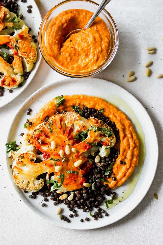 Cauliflower steaks with lemon-caper black lentils and harissa white bean puree: An impressive main course or side that celebrates the versatility of plant-based ingredients in a delicious way.