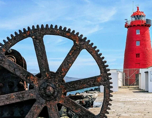 Rusted metal wheel in the foreground, Poolbeg Lighthouse behind