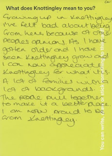 Yellow postcard with handwritten text that reads "Growing up in Knottingley I've felt bad about being from here, because of other's people's opinions. As I have gotten older and I have seen Knottingley grow and I can now appreciate Knottingley for what it is. A lot of families with a lot of backgrounds. The people pull together to make it a better place. I am now proud to be from Knottingley"