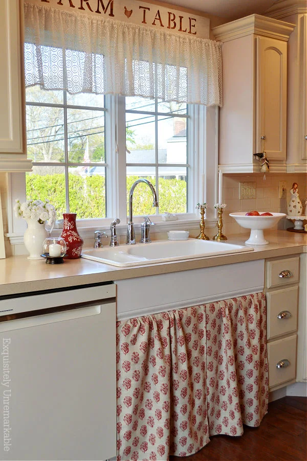 Farmhouse Cottage Style Kitchen with red and white DIY sink skirt mounted to cabinet doors